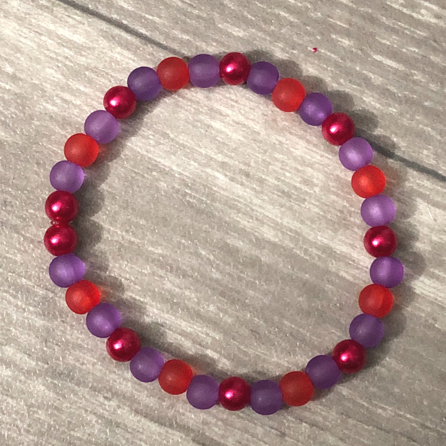 Handmade beaded bracelet with red and purple beads