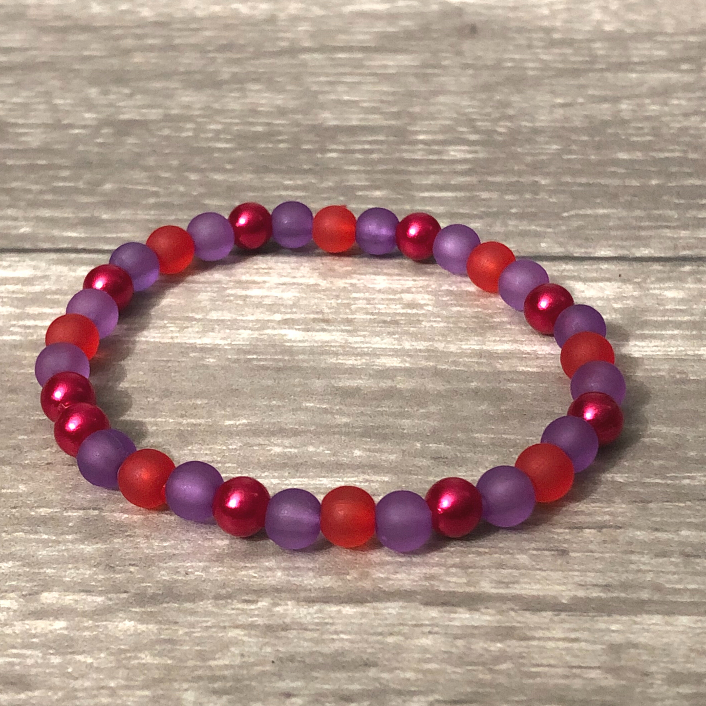 Handmade beaded bracelet with red and purple beads